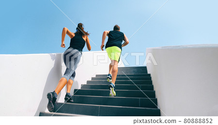 Stairs runners running up staircase training hiit workout. Couple working out legs and cardio at fitness gym. Healthy active lifestyle sport people exercising climbing staircase in urban city. 80888852