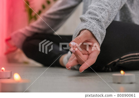 Close-up. Woman doing yoga exercise at home. Mindfulness meditation. Relax breathe easy pose gym healthy lifestyle concept. Burning candles light. Lotus asana. Atmosphere of relax and zen. 80890061