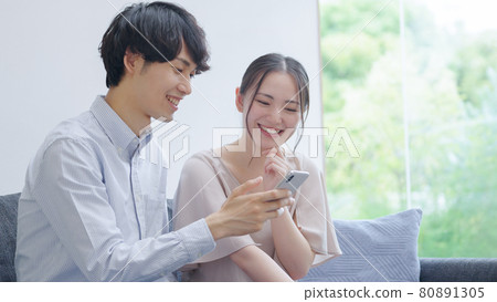 Young couples looking at smartphones Young couples looking at smartphones 80891305