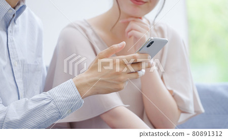 Young couples looking at smartphones 80891312