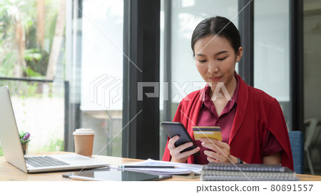 Asian woman holding credit card and shopping online with smart phone. 80891557