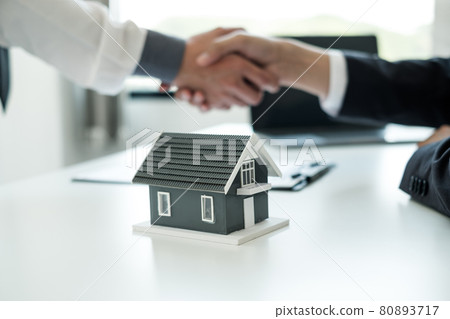 Businessmen and brokers' real estate agents shake hands after completing negotiations to buy houses insurance and sign contracts. Home insurance concept 80893717