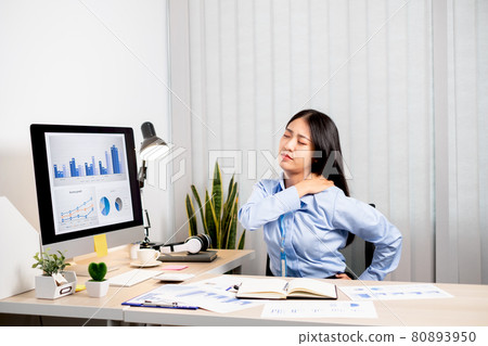 Asian female accountant is tired from working in a chair, stretching to relax and relax while working hard at the office Asian female accountant is tired from working in a chair, stretching to relax and relax while working hard at the office 80893950