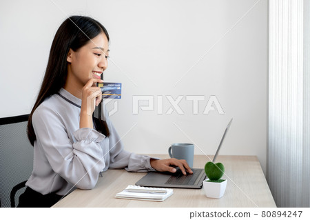 The Asian businesswoman's hand is holding a credit card and using a laptop for online shopping The Asian businesswoman's hand is holding a credit card and using a laptop for online shopping 80894247