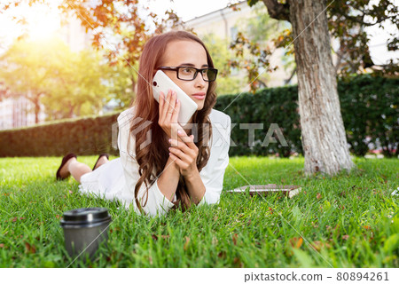 woman in the park with phone woman in the park with phone 80894261