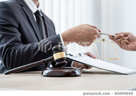 A male lawyer or a judge counseling clients about judicial justice and prosecution with scales, judges gavel, legal documents legal services concept A male lawyer or a judge counseling clients about judicial justice and prosecution with scales, judges gavel, legal documents legal services concept 80894649