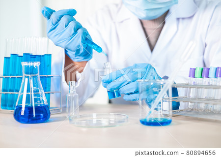 Medical scientists released a sample pipetted into a test flask to analyze the virus in a chemical laboratory. Scientific research concepts 80894656
