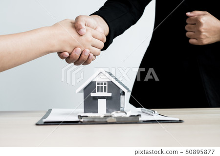 Businessmen and brokers real estate agents shake hands after completing negotiations to buy houses insurance and sign contracts. Home insurance concept 80895877