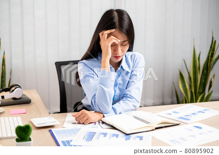 Working Asian women feel stressed, tired from work, migraine headaches from hard work while working at the office Working Asian women feel stressed, tired from work, migraine headaches from hard work while working at the office 80895902