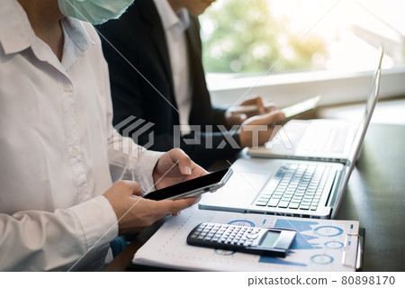 Business people discussing on performance revenue in meeting.mask for corona virus. financial adviser analyzing data with investor at office. Business people discussing on performance revenue in meeting.mask for corona virus. financial adviser analyzing data with investor at office. 80898170