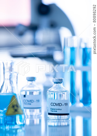 Bottle of COVOD-19 vaccine sample in a laboratory with lab equipment in blur background. Idea for researching and lab tests for coronavirus curing 80898292