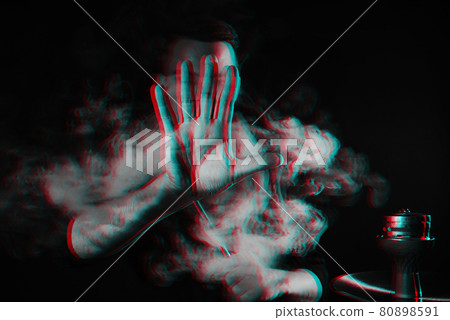 male smoker smokes a hookah in a shisha bar and lets out a cloud of smoke male smoker smokes a hookah in a shisha bar and lets out a cloud of smoke 80898591