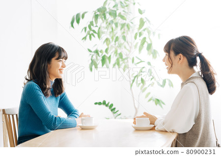 Two women chatting at a cafe Two women chatting at a cafe 80900231