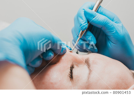 The beautician cleanses the patient's skin with a spoon uno, moisturizing, cleansing and skin care. The beautician cleanses the patient's skin with a spoon uno, moisturizing, cleansing and skin care. 80901453