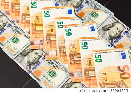 euros and dollars lie in a row, banknotes of euro and dollars on a black background. euros and dollars lie in a row, banknotes of euro and dollars on a black background. 80901895