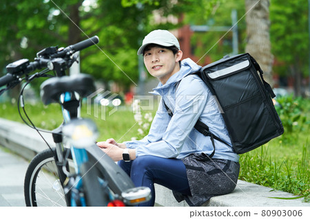 一個騎自行車在城里送貨的人 80903006