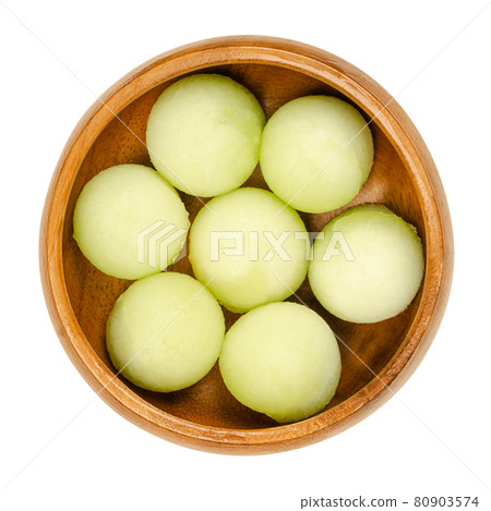 Galia melon balls, in a wooden bowl. Freshly cut out with a melon baller, ready-to-eat pieces of a ripe fruit of Cucumis melo var. reticulatus, a sweet and aromatic melon, also known as sarda. Photo. Galia melon balls, in a wooden bowl. Freshly cut out with a melon baller, ready-to-eat pieces of a ripe fruit of Cucumis melo var. reticulatus, a sweet and aromatic melon, also known as sarda. Photo. 80903574