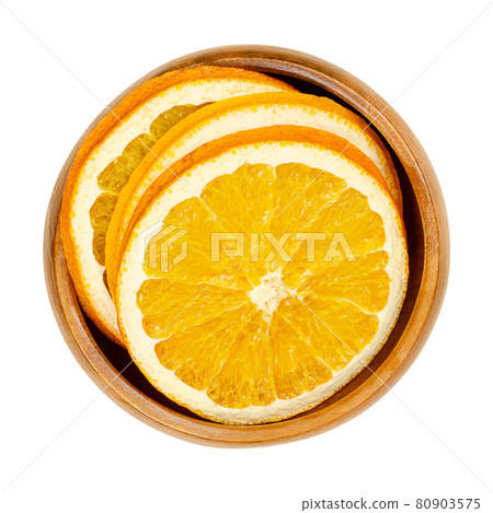 Dried orange slices, in a wooden bowl. Oranges, cut into cross sections, sliced fruits, used as aromatic smelling Christmas decoration. Close-up, from above, isolated on white background, macro photo. 80903575