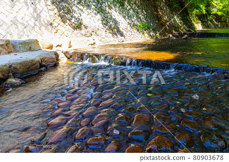 River water flowing through the cobblestones 80903678