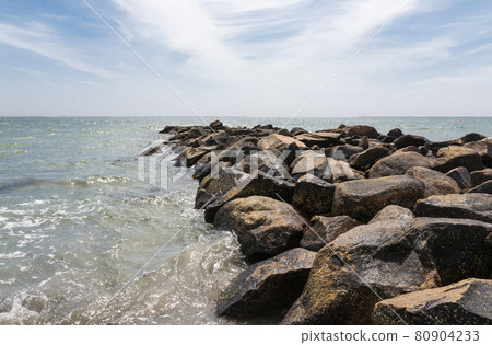Jetty of rock boulders extending out into the ocean in Narragansett Rhode Island Jetty of rock boulders extending out into the ocean in Narragansett Rhode Island 80904233