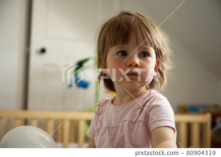 Lifestyle portrait of a smiling cute todler girl. Child education, parenting concept. 80904319
