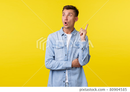 Excited handsome smart guy have interesting idea, looking up and raise index finger in eureka gesture, suggest solution, think-up great plan, standing yellow background Excited handsome smart guy have interesting idea, looking up and raise index finger in eureka gesture, suggest solution, think-up great plan, standing yellow background 80904585