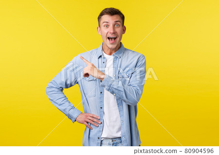 Enthusiastic happy handsome blond man in stylish outfit, pointing finger upper left corner and smiling broadly, found out amazing great news, showing special offer banner, yellow background Enthusiastic happy handsome blond man in stylish outfit, pointing finger upper left corner and smiling broadly, found out amazing great news, showing special offer banner, yellow background 80904596