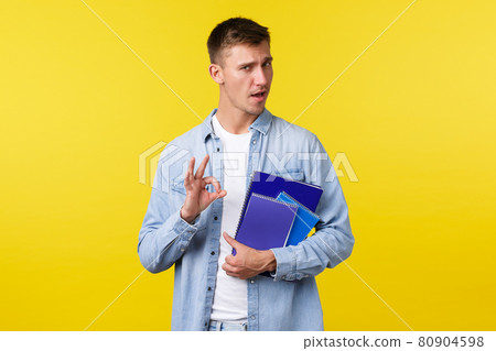 Education, courses and university concept. Handsome assured blond guy encourage enroll this college, showing okay gesture as guarantee you will like it, holding notebooks, yellow background Education, courses and university concept. Handsome assured blond guy encourage enroll this college, showing okay gesture as guarantee you will like it, holding notebooks, yellow background 80904598