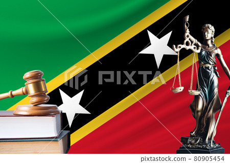 Law and justice in St. Kitts and Nevis. Statue of themis and the gavel of the judge against the background of the flag of St. Kitts and Nevis. Law and justice concept 80905454