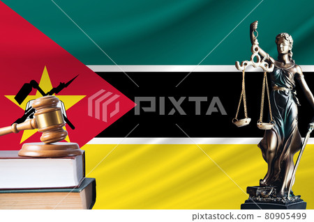 Law and justice in Mozambique. Statue of themis and the gavel of the judge against the background of the flag of Mozambique. Law and justice concept Law and justice in Mozambique. Statue of themis and the gavel of the judge against the background of the flag of Mozambique. Law and justice concept 80905499