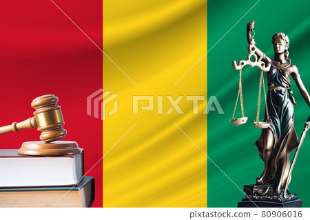 Law and justice in Guinea. Statue of themis and the gavel of the judge against the background of the flag of Guinea. Law and justice concept 80906016