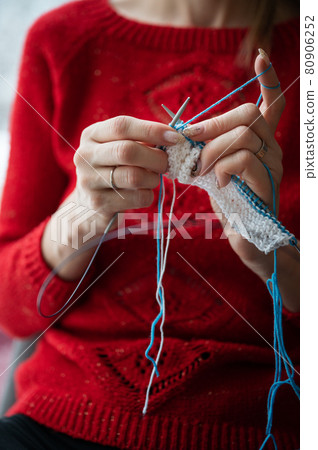 Closeup view of a woman knitting a scarf 80906252