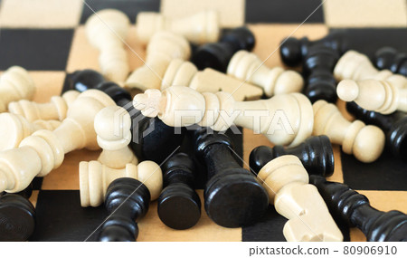 Heap of chess pieces on chess board top view Heap of chess pieces on chess board top view 80906910