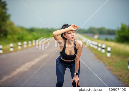 Fitness runner athlete listening to music in headphones from mobile smart phone app tracking progress. workout wellness concept. 80907408