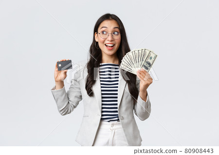 Business, finance and employment, entrepreneur and money concept. Thoughtful successful female office manager, employer thinking how invest cash, holding dollars and credit card 80908443
