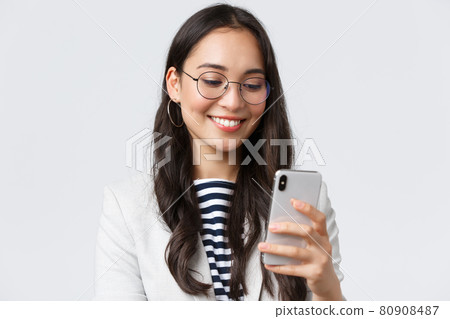 Business, finance and employment, female successful entrepreneurs concept. Close-up of stylish modern businesswoman in suit and glasses messaging, using mobile phone 80908487