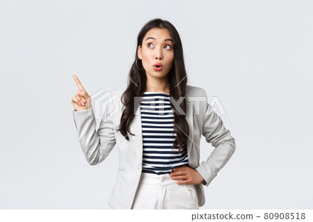 Business, finance and employment, female successful entrepreneurs concept. Cheerful successful businesswoman in white suit pointing fingers upper left corner, showing advertisement Business, finance and employment, female successful entrepreneurs concept. Cheerful successful businesswoman in white suit pointing fingers upper left corner, showing advertisement 80908518