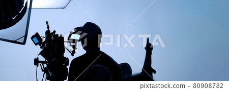 Video production behind the scenes. Making of TV commercial movie that film crew team lightman and cameraman working together with film director in studio. film production concept. Silhouette style. Video production behind the scenes. Making of TV commercial movie that film crew team lightman and cameraman working together with film director in studio. film production concept. Silhouette style. 80908782