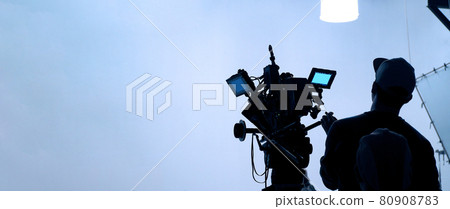 Video production behind the scenes. Making of TV commercial movie that film crew team lightman and cameraman working together with film director in studio. film production concept. Silhouette style. Video production behind the scenes. Making of TV commercial movie that film crew team lightman and cameraman working together with film director in studio. film production concept. Silhouette style. 80908783