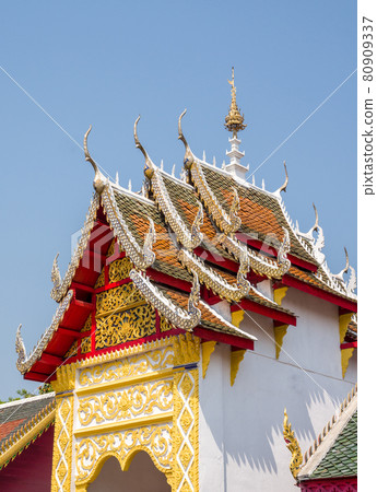 Carved floral pattern in the traditional Thai style on the gable of the Thai church. 80909337