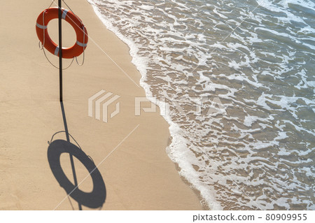 Red life buoy on an empty sandy beach Red life buoy on an empty sandy beach 80909955