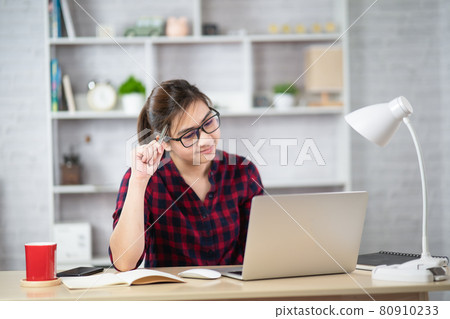 Beautiful asian woman relaxing using laptop computer while sitting on table. Creative girl working and typing on keyboard at home.work at home concept 80910233