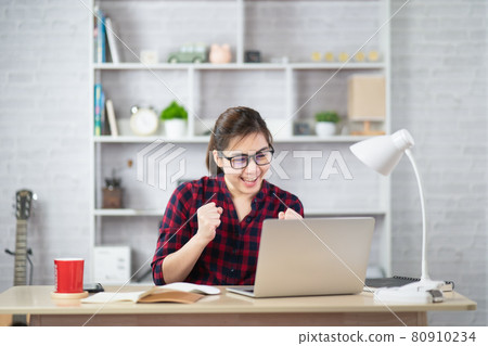Beautiful asian woman relaxing using laptop computer while sitting on table. Creative girl working and typing on keyboard at home.work at home concept Beautiful asian woman relaxing using laptop computer while sitting on table. Creative girl working and typing on keyboard at home.work at home concept 80910234