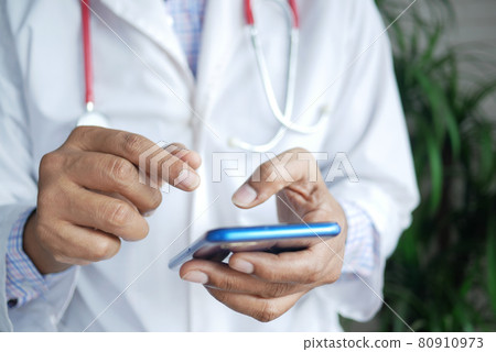 doctor in white coat using a smartphone. 80910973