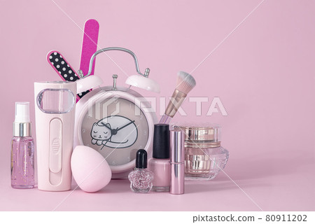 Group of makeup cosmetics with round clock on pink background Group of makeup cosmetics with round clock on pink background 80911202