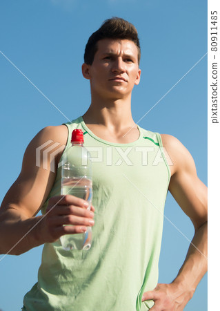 Man with water bottle in muscular hands Man with water bottle in muscular hands 80911485