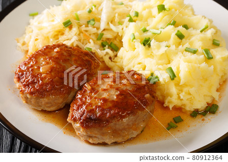 Tasty menu Norwegian pork meatballs Medisterkaker served with mashed potatoes and sauerkraut close-up in a plate. horizontal Tasty menu Norwegian pork meatballs Medisterkaker served with mashed potatoes and sauerkraut close-up in a plate. horizontal 80912364