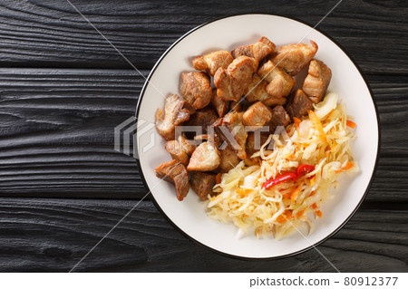 Griot is a dish in Haitian cuisine it consists of pork shoulder marinated in citrus, which is braised and then fried close-up in a plate. Horizontal top view Griot is a dish in Haitian cuisine it consists of pork shoulder marinated in citrus, which is braised and then fried close-up in a plate. Horizontal top view 80912377