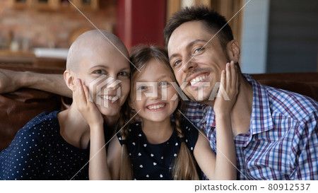 Happy family sitting on couch at home together Happy family sitting on couch at home together 80912537