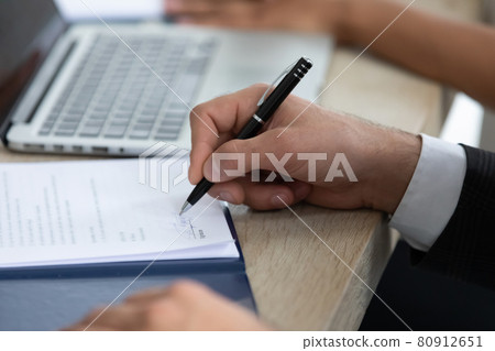 Close up of male sing paperwork closing business deal Close up of male sing paperwork closing business deal 80912651